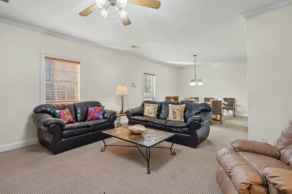 a living room with furniture a ceiling fan and a rug