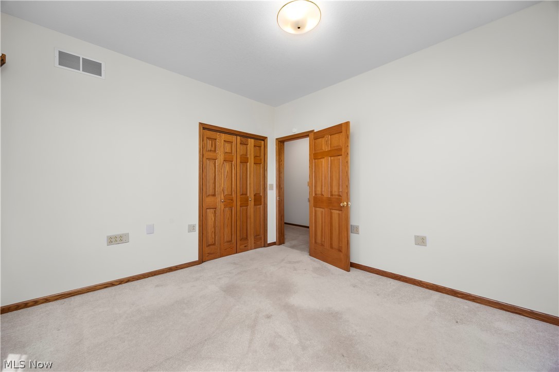 51488 Peck Wadsworth Road Wellington, OH 44090 - Photo 41 of 50 Carpeted room featuring light-colored walls, wood-finish trim, and a flush mount ceiling light