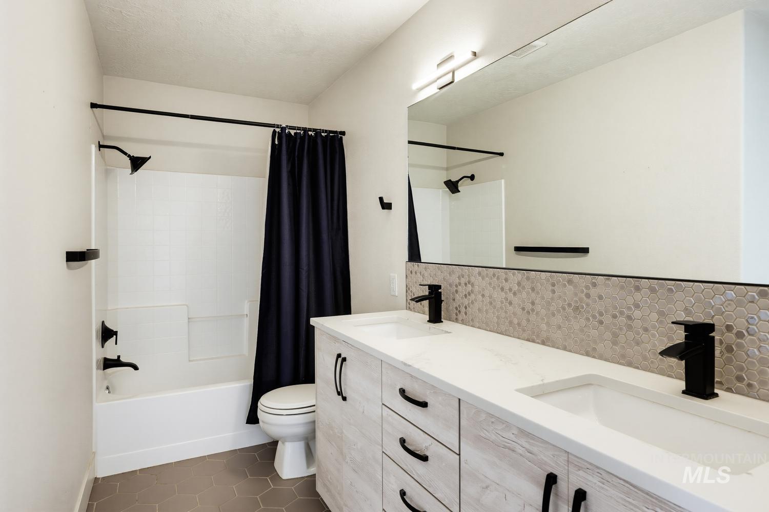 369 South Winthrop Way Boise, ID 83709 - Photo 34 of 50 Bathroom featuring a dual vanity with white countertops, integrated sinks, and matte black fixtures