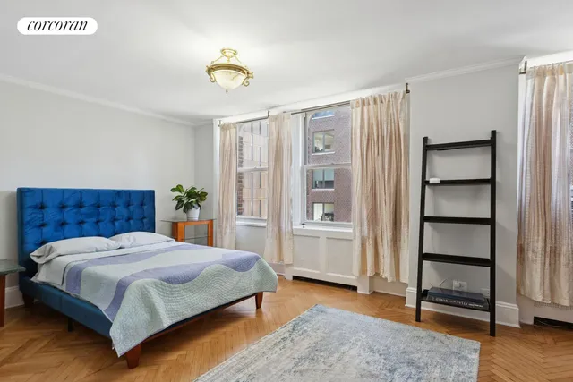 a bedroom with a bed a table and painting on the wall