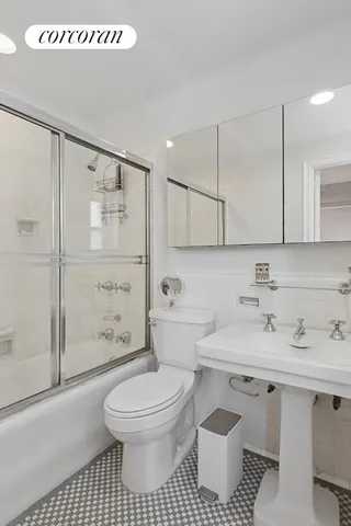 a bathroom with a sink toilet a mirror and shower