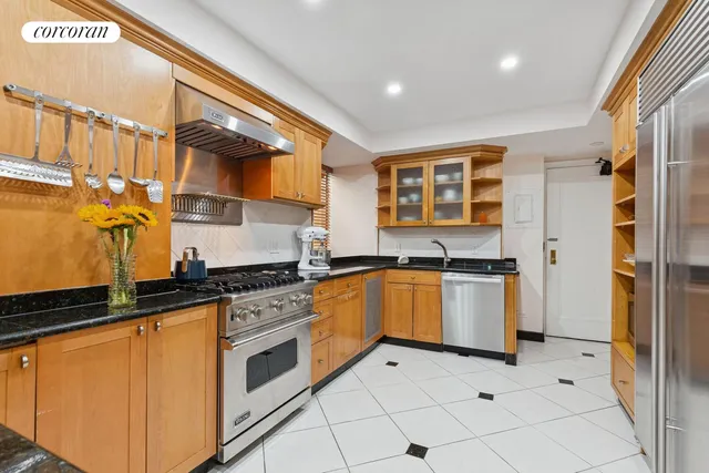 a kitchen with stainless steel appliances granite countertop a stove a sink and a refrigerator