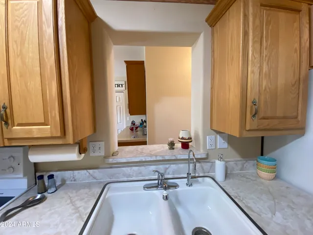 a kitchen with kitchen island granite countertop a sink stove and cabinets