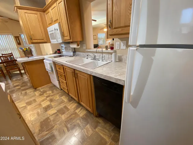 a kitchen with a table chairs a oven a clock and cabinets