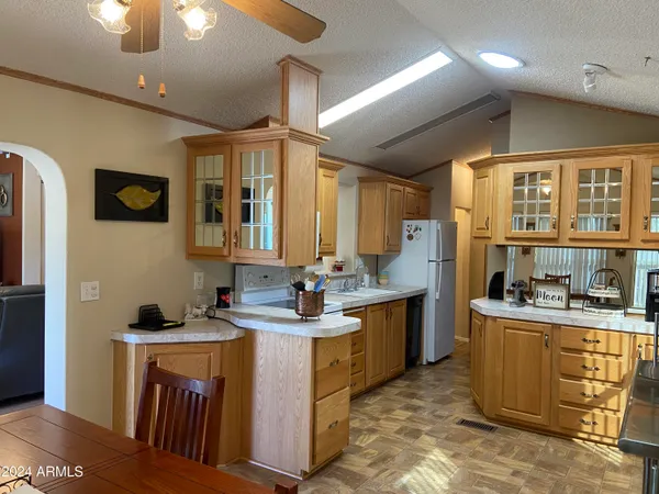 a kitchen with kitchen island granite countertop a sink stove and cabinets