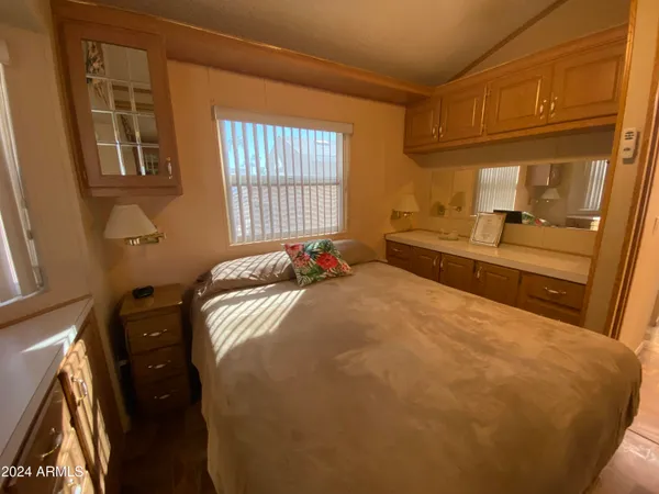 a bedroom with a bed and wooden floor