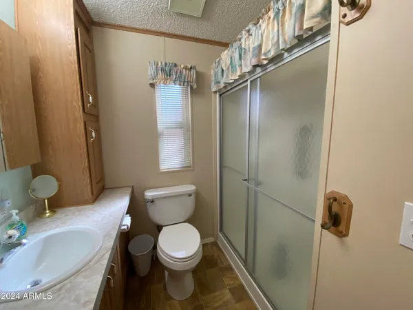 a bathroom with a granite countertop sink toilet and shower