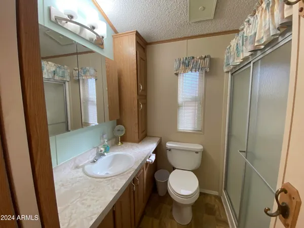 a bathroom with a granite countertop sink toilet and shower