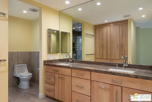 a bathroom with a granite countertop sink mirror and toilet