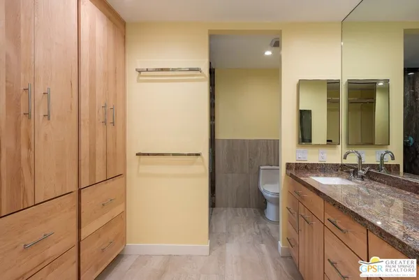 a bathroom with a granite countertop sink and a mirror