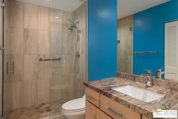 a bathroom with a granite countertop sink toilet and shower