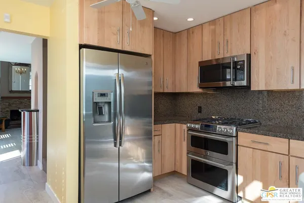 a kitchen with stainless steel appliances granite countertop a refrigerator and a stove