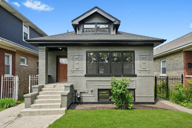 a front view of a house with a garden and plants