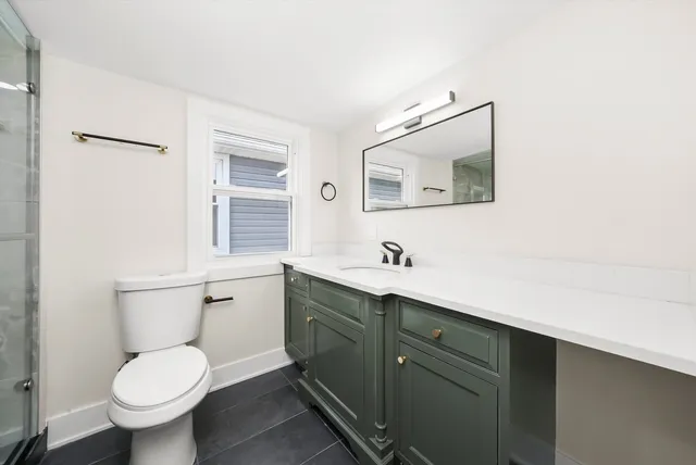 a bathroom with a toilet sink and mirror