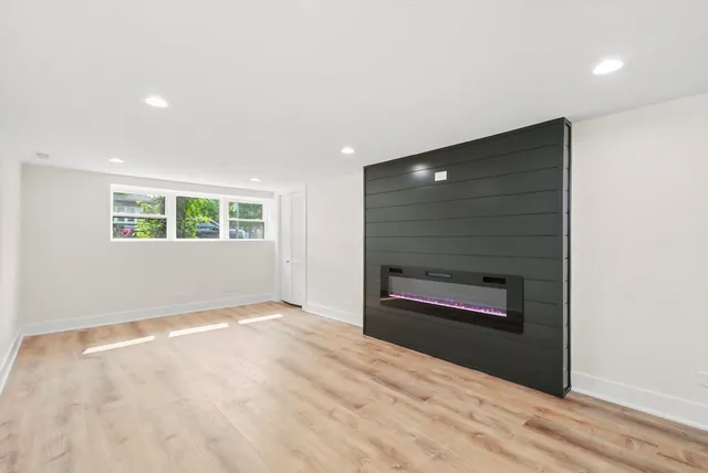 a view of an empty room with a fireplace and a window