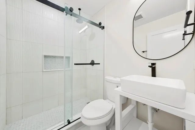 a bathroom with a toilet a sink and a shower