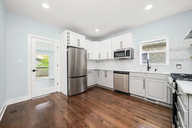 a kitchen with granite countertop a refrigerator stove and sink