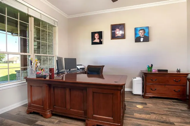 a view of a workspace with furniture and a window