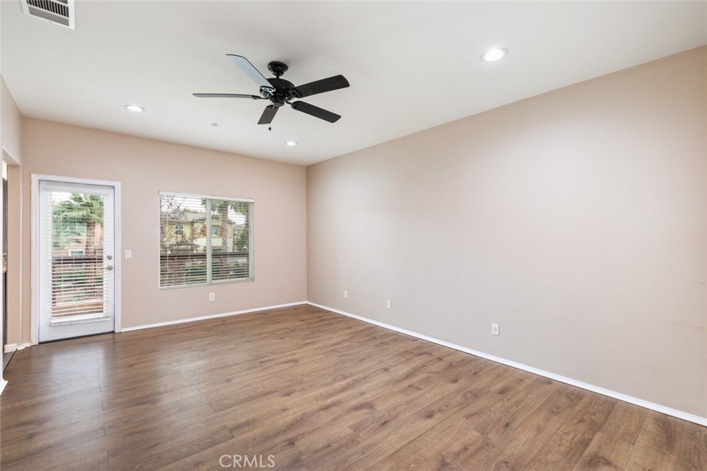 6228 Manzanita Way Riverside, CA 92504 - Photo 15 of 42 an empty room with wooden floor fan and windows