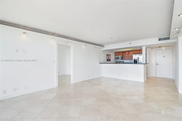 a view of a kitchen with an empty space and a window