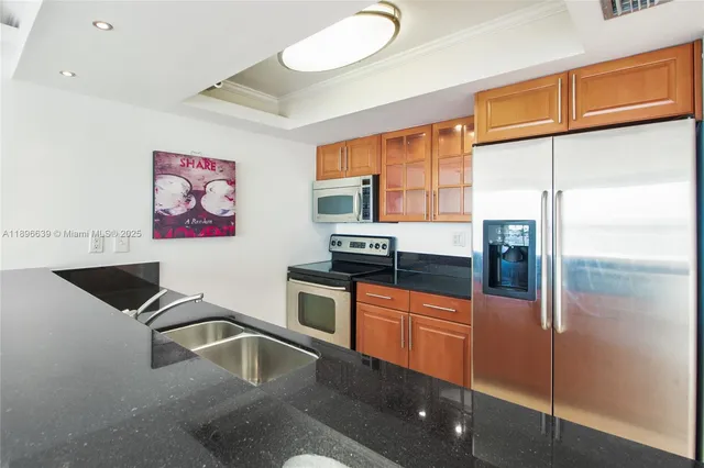 a kitchen with granite countertop a refrigerator and a sink