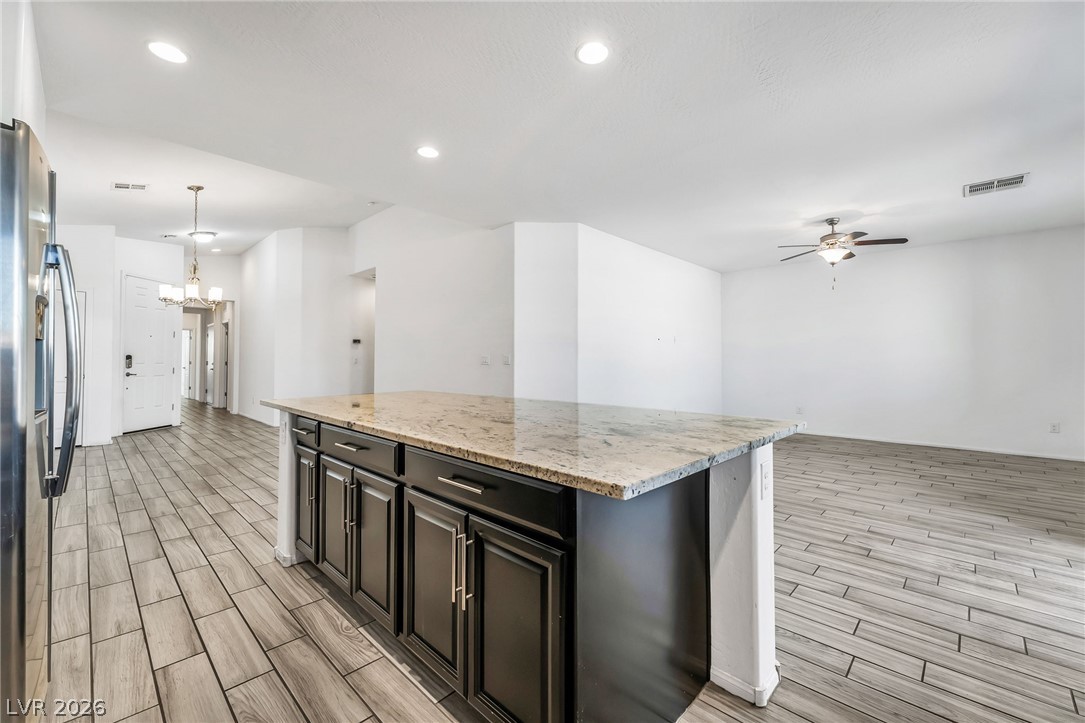 6245 Andover Wood Road Las Vegas, NV 89113 - Photo 11 of 37 An inviting open-concept layout connects the kitchen island with the spacious living area.