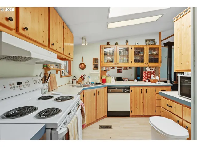 a kitchen with a sink a stove and white cabinets