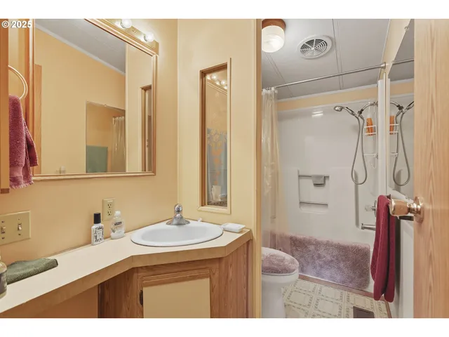 a bathroom with a granite countertop sink a mirror a vanity and shower