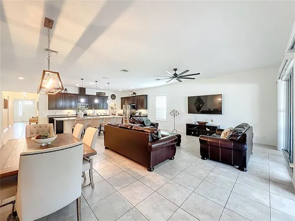 a living room with furniture ceiling fan and a large window
