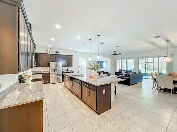 a kitchen with stainless steel appliances granite countertop a sink a stove and a wooden floors