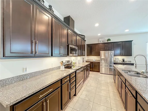 a kitchen with stainless steel appliances granite countertop a stove a sink and a refrigerator