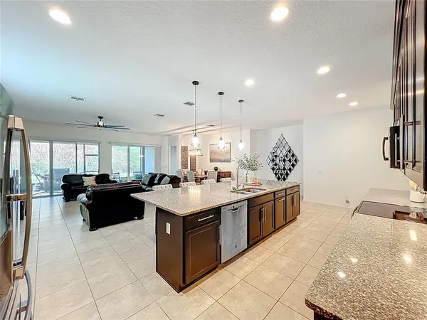 a living room with stainless steel appliances furniture and a chandelier