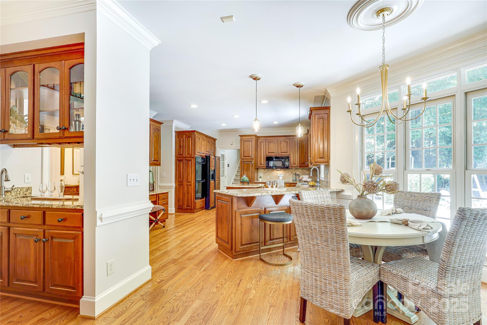 2500 High Ridge Road Charlotte, NC 28270 - Photo 11 of 47 a view of a dining room and livingroom with furniture wooden floor a chandelier