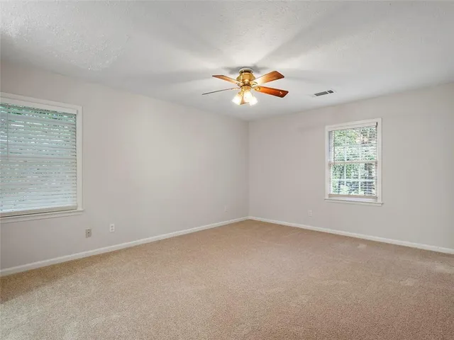 an empty room with a window and a ceiling fan