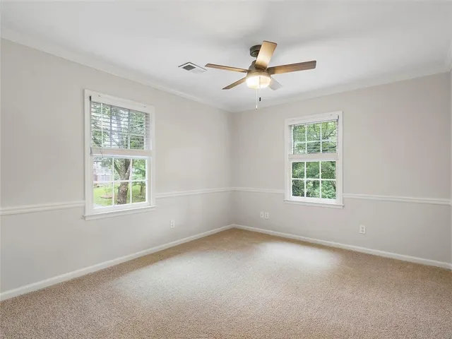an empty room with a window and a fan
