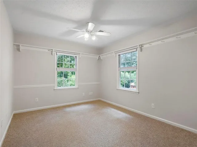 an empty room with a window and a fan