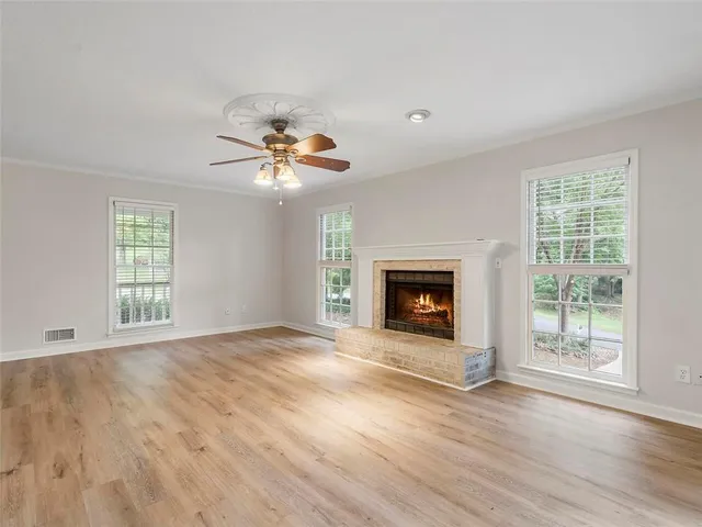 a view of an empty room with a window and fireplace