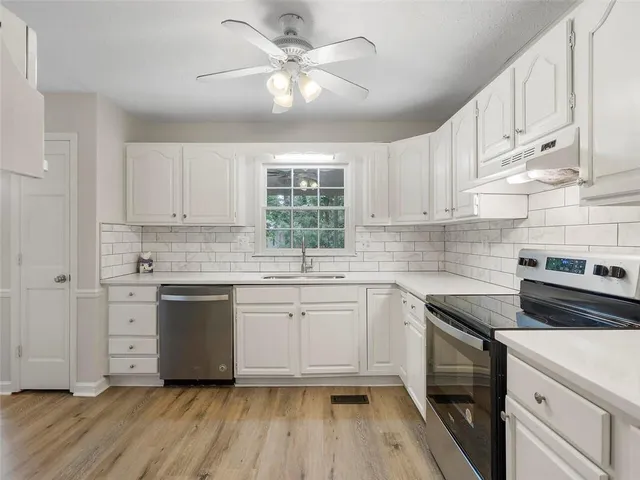 a kitchen with granite countertop white cabinets and white appliances