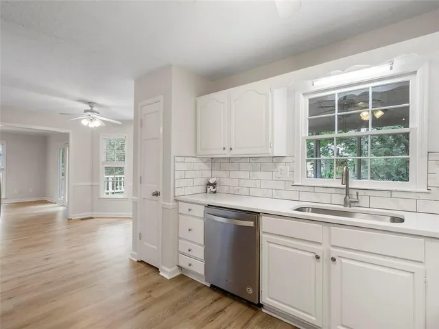 a kitchen with a sink cabinets appliances and a window