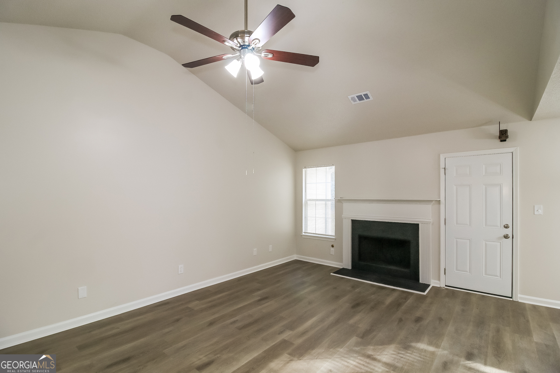 7010 New Dale Road Rex, GA 30273 - Photo 4 of 16 an empty room with fan and fireplace