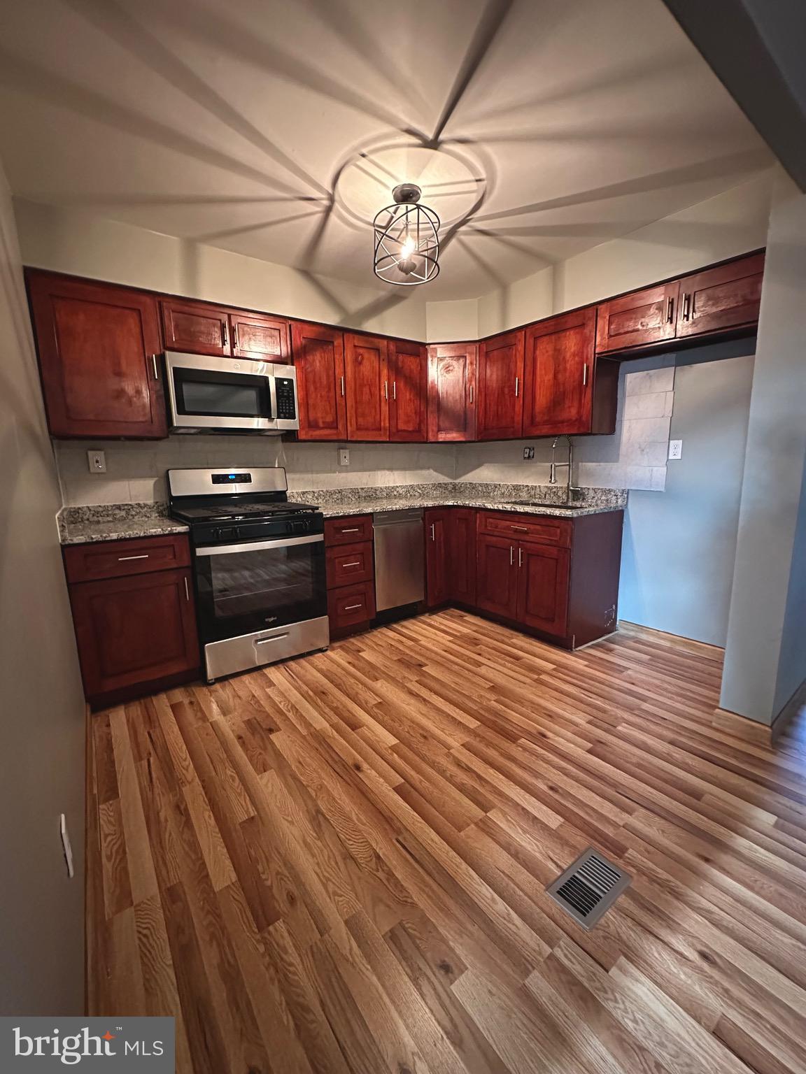 12077 Abby Road Philadelphia, PA 19154 - Photo 3 of 27 a large kitchen with stainless steel appliances granite countertop a lot of cabinets and wooden floor