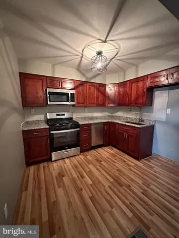 a kitchen with stainless steel appliances wooden cabinets a sink and a stove