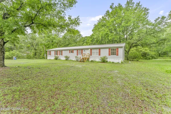 a view of a house with yard and sitting area