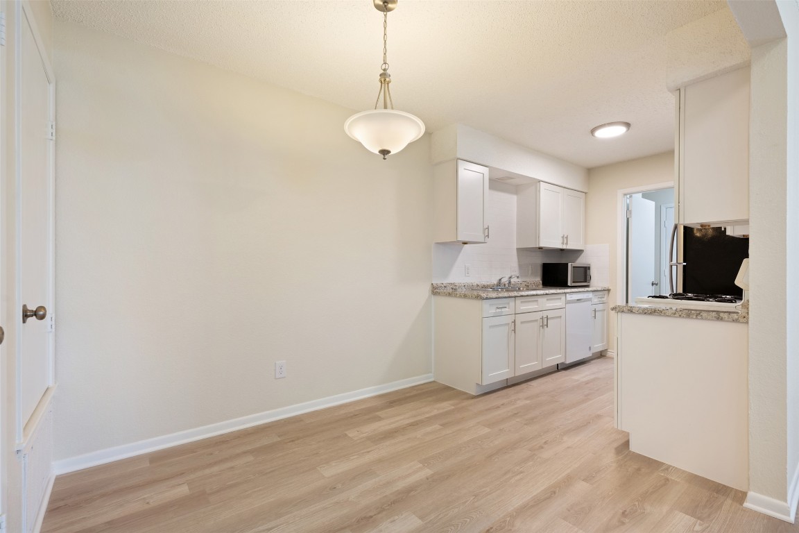 608 Country Aire Drive, Unit A Round Rock, TX 78664 - Photo 11 of 32 a kitchen with a refrigerator and white cabinets