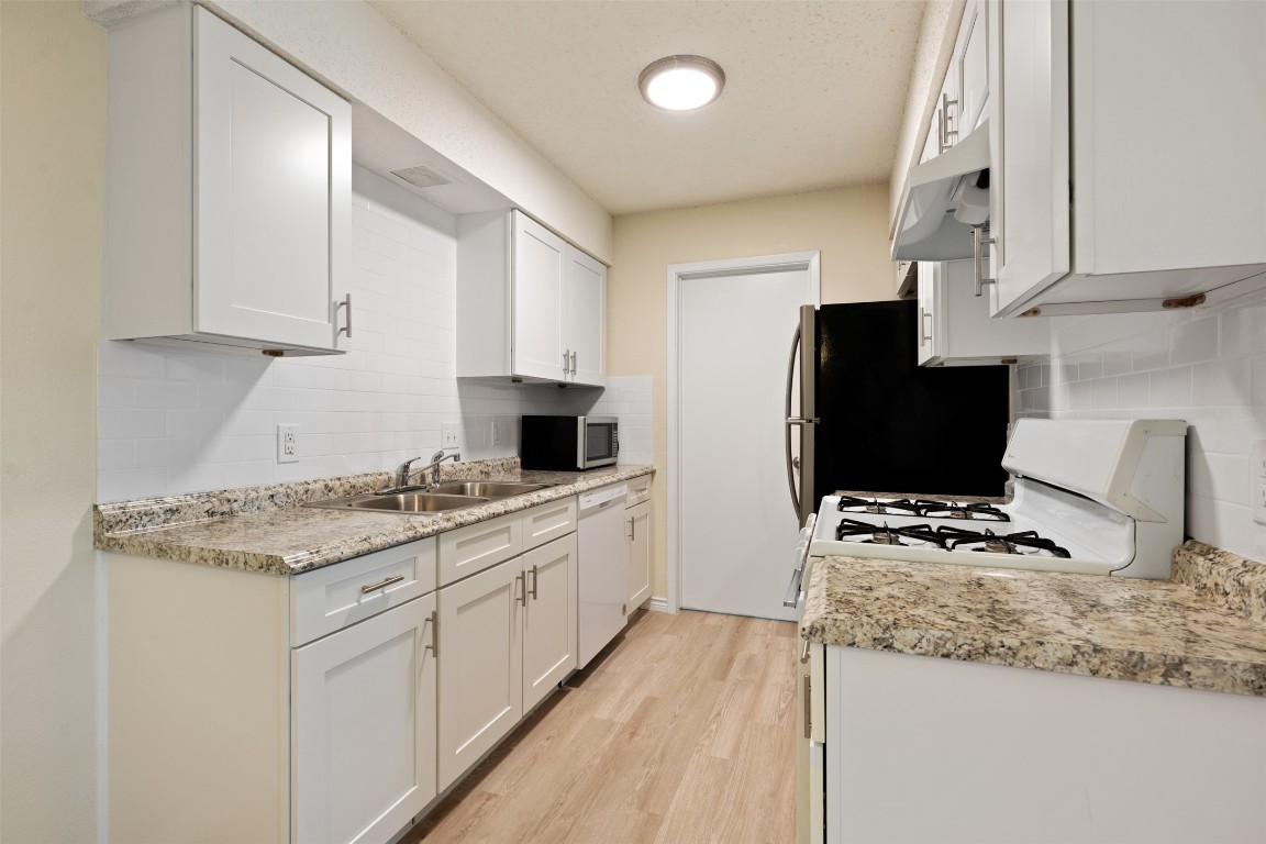 608 Country Aire Drive, Unit A Round Rock, TX 78664 - Photo 14 of 32 a kitchen with granite countertop a sink stove and refrigerator