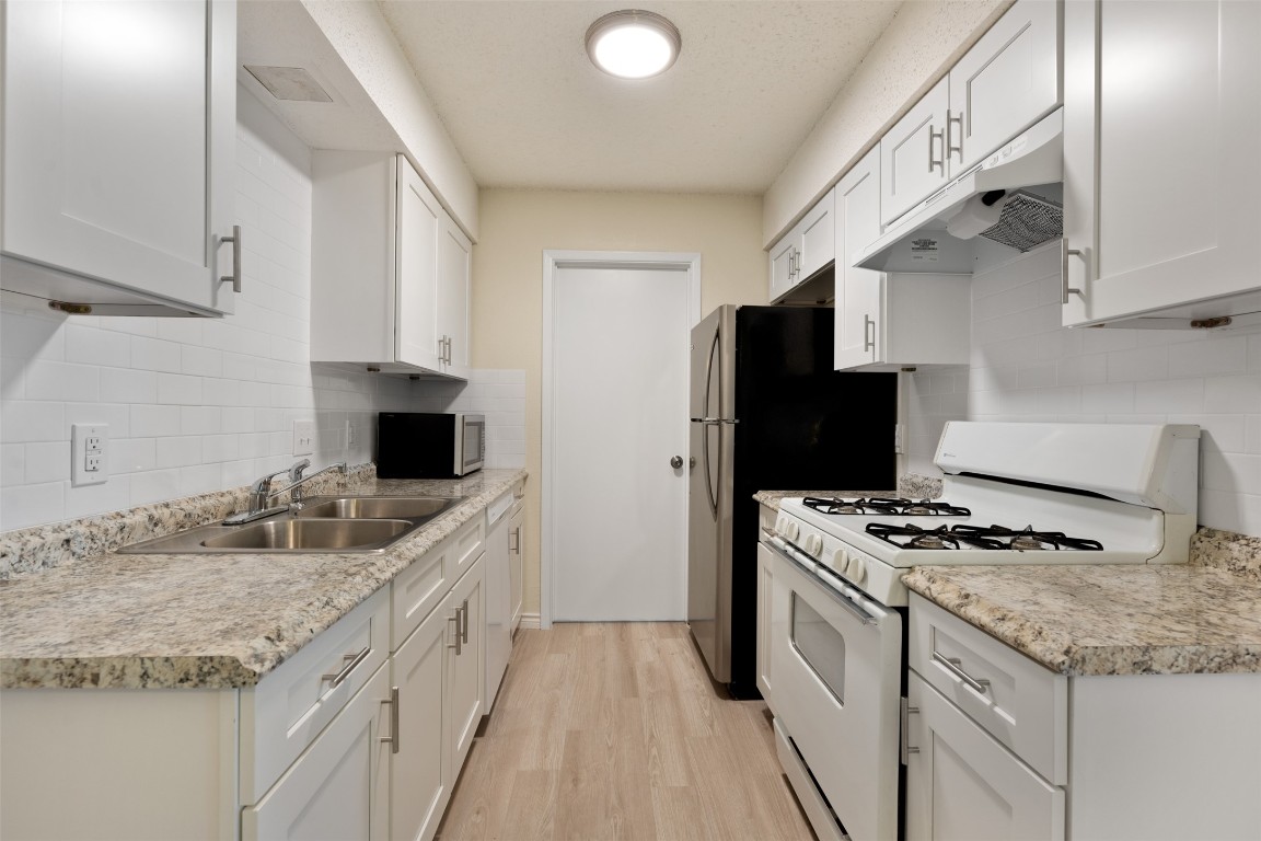 608 Country Aire Drive, Unit A Round Rock, TX 78664 - Photo 15 of 32 a kitchen with granite countertop stainless steel appliances a sink stove and refrigerator
