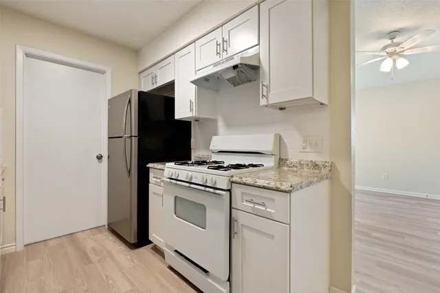 a kitchen with stainless steel appliances a stove a refrigerator and cabinets