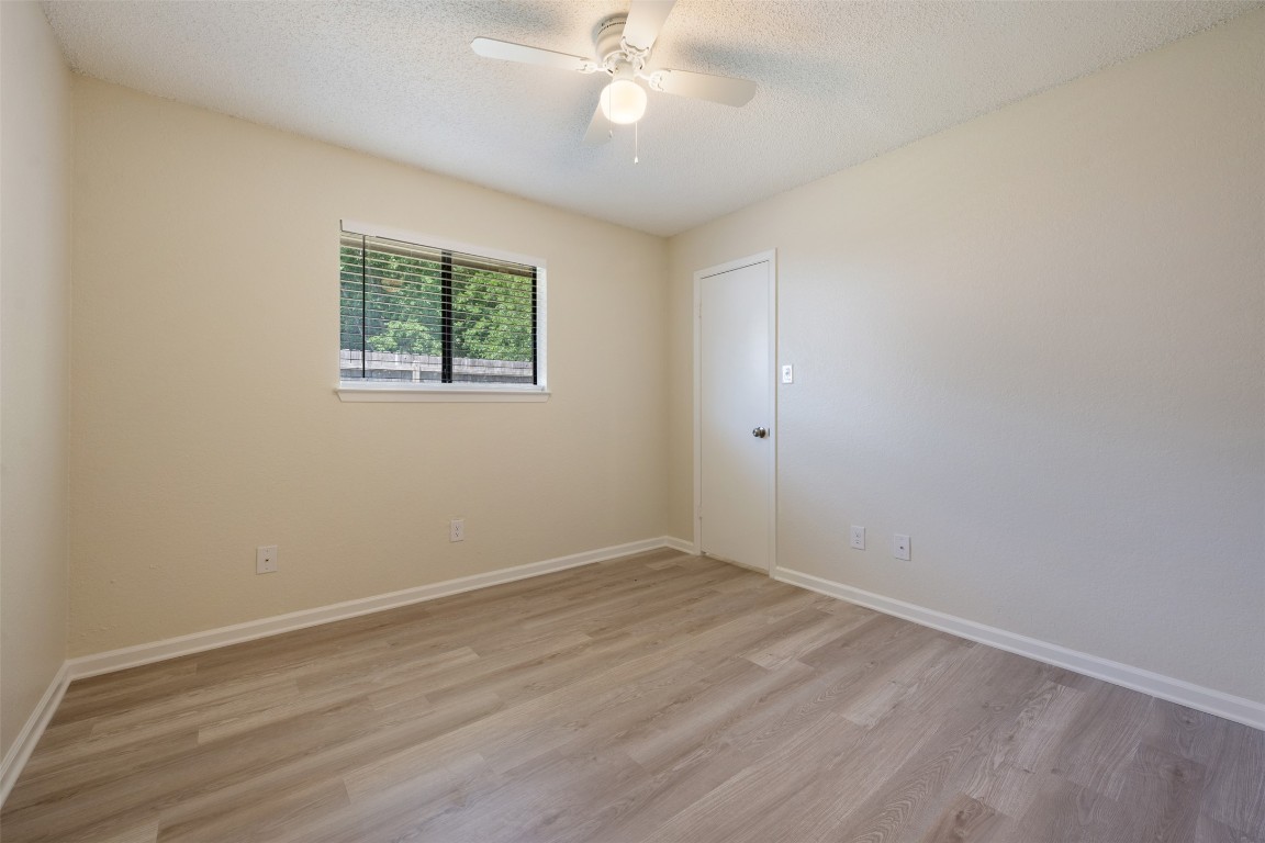 608 Country Aire Drive, Unit A Round Rock, TX 78664 - Photo 22 of 32 wooden floor in an empty room with a window