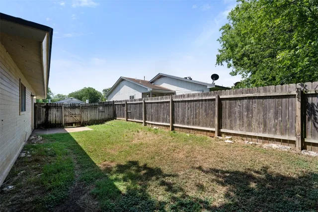 a view of backyard with wooden fence