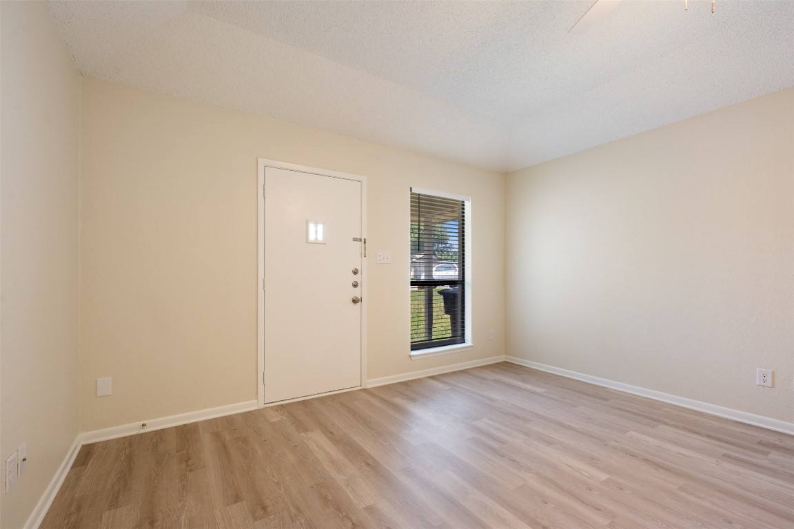 608 Country Aire Drive, Unit A Round Rock, TX 78664 - Photo 5 of 32 an empty room with wooden floor and windows